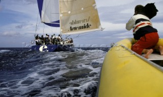 Cameraman filming yacht racing from a yellow RIB