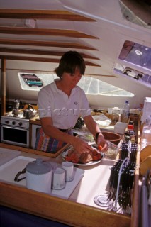 Cook prepares food on a large sailing cruising yacht