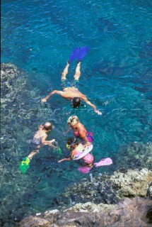Family snorkelling in clear, shallow water