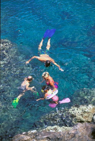 Family snorkelling in clear shallow water