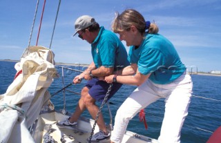 Two crew members pulling up the anchor