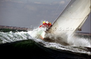 Crew on rail of yacht in rough seas during the Fastnet race