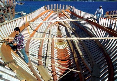 Boat builders construct the hull of a wooden ship in Caicchi Shipyard Turkey
