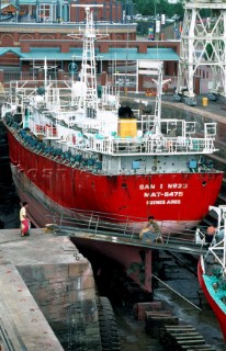 Commercial ship undergoing maintenance in dry dock of shipyard