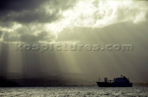 Cargo ship at anchore under stormy sky
