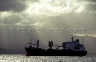 Cargo ship at anchore under stormy sky