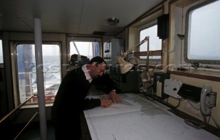 Salvage tug chart room. Officer plotting ships course on a chart