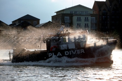 Spray from a bow wave flies over a Port of London Authority Dive vessel