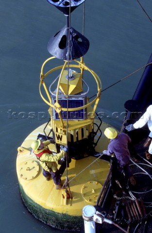 Crew of a maintenance vessel carry out work on a cardinal buoy