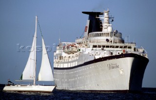 Yacht sails infront of luxury cruise ship Lady Danae