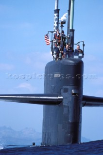 Sailors standing on top of a US Navy submarines conning tower