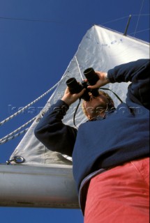 Crew on board yacht looking through binoculars