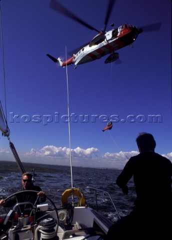Emergency helicopter coastguard rescue from a sailing cruising yacht