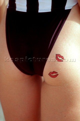 Close up of two red lips tattoos on the check of a womans backside
