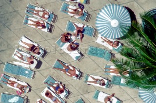 Aerial view of sunbathers by a hotel pool