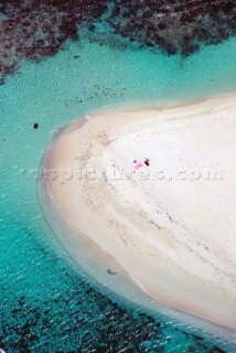 Aerial view of two towels on round edge of secluded beach