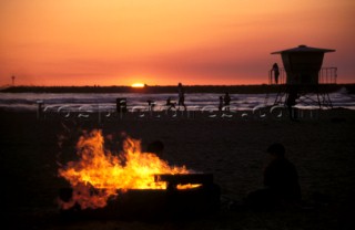 Camp fire on the beach at sunset