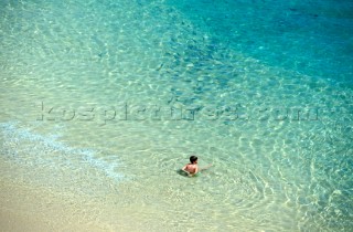 Sunbather lying in shallow water on beach
