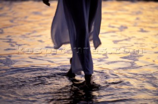 Close up of woman walking through sea on the shore