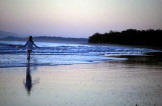 Woman on secluded beach at sunset