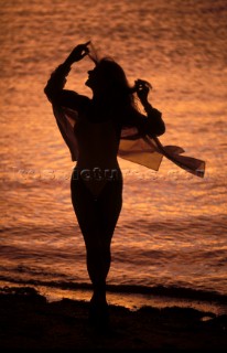 Silhouette of woman on beach at sunset