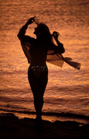 Silhouette of woman on beach at sunset