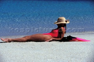Woman lying on beach looking out to sea