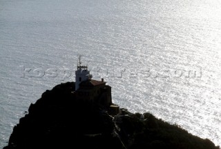 Lighthouse perched on top of steep rocky cliff