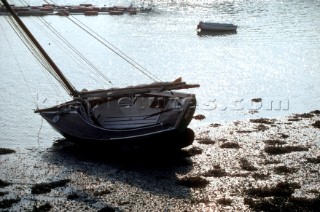 A sailing dinghy beached at low tide