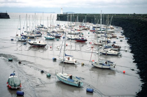 Boats in muddy harbour at low tide