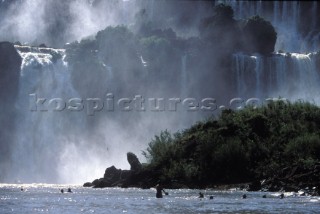 Bathers swim at the foot of Iguazu Falls, Argentina