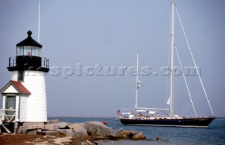 Sailing yacht Lighthouse motors passed lighthouse on rocks