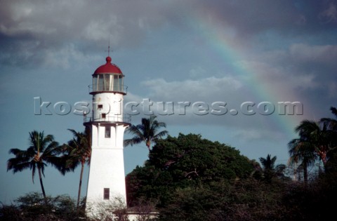 Rainbow over white lighthouse in Hawaii
