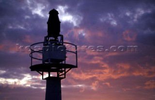 Detail of navigation beacon under clouds lit by sunrise