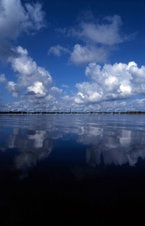 Blue sky and clouds reflected in flat water