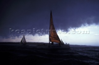 Yachts sailing under a stormy sky