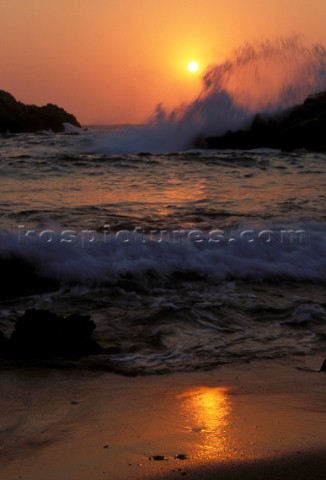 Sea breaking on rocks at sunset Island of Kos Greece