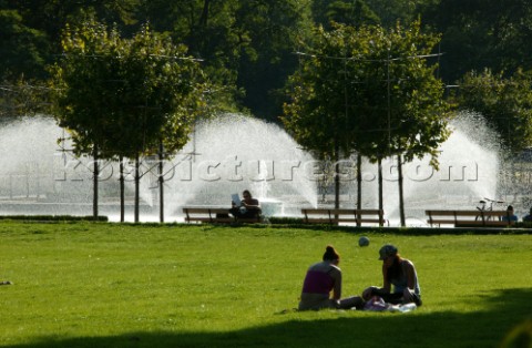 Two people relax by the fountains in Battersea Park London
