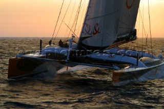 Maxi catamaran Orange skippered by Bruno Peyron crossing the startline of the Jules Verne