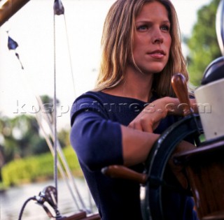 Girl steering classic yacht