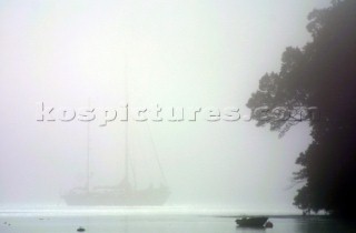 Yachts in the fog and mist on the River Dart in Devon