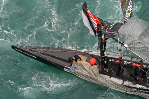 Crew members onboard Team New Zealands NZL82 pull in the jib after breaking their mast during race f