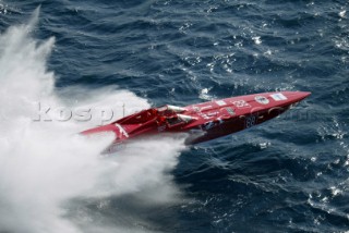 A powerboat crashes through a wave