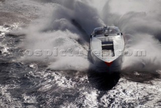 Aerial shot of powerboat crashing through a wave.