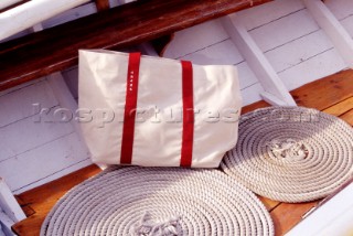 Sailing bag and coiled rope on deck of classic yacht.