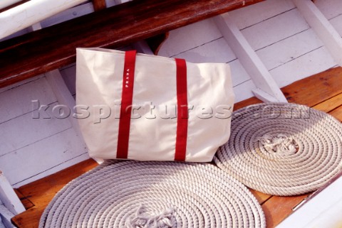 Sailing bag and coiled rope on deck of classic yacht