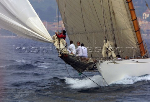 Crew on bowsprit of classic yacht  