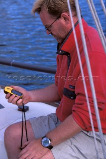 Man on boat using hand-held GPS instrument