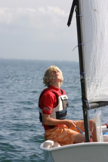 Young sailor checks the trim of his sail