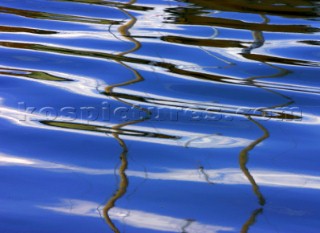 Reflection of boat masts in rippled water